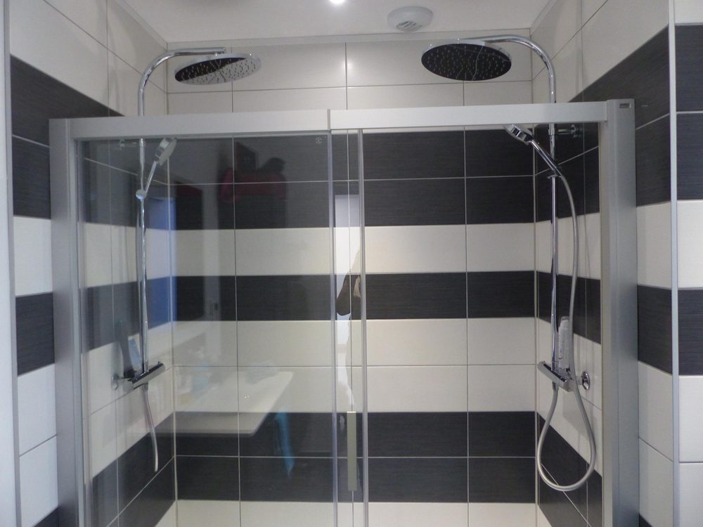 Douche à l'italienne avec paroi vitrée et faïence noire et blanche